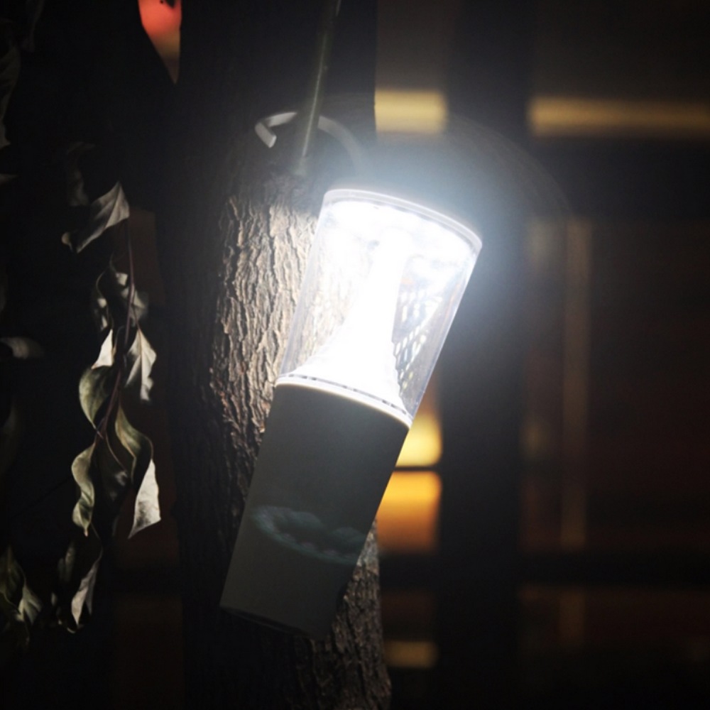 lampe accrochée à une petite branche d'arbre et allumée à fond